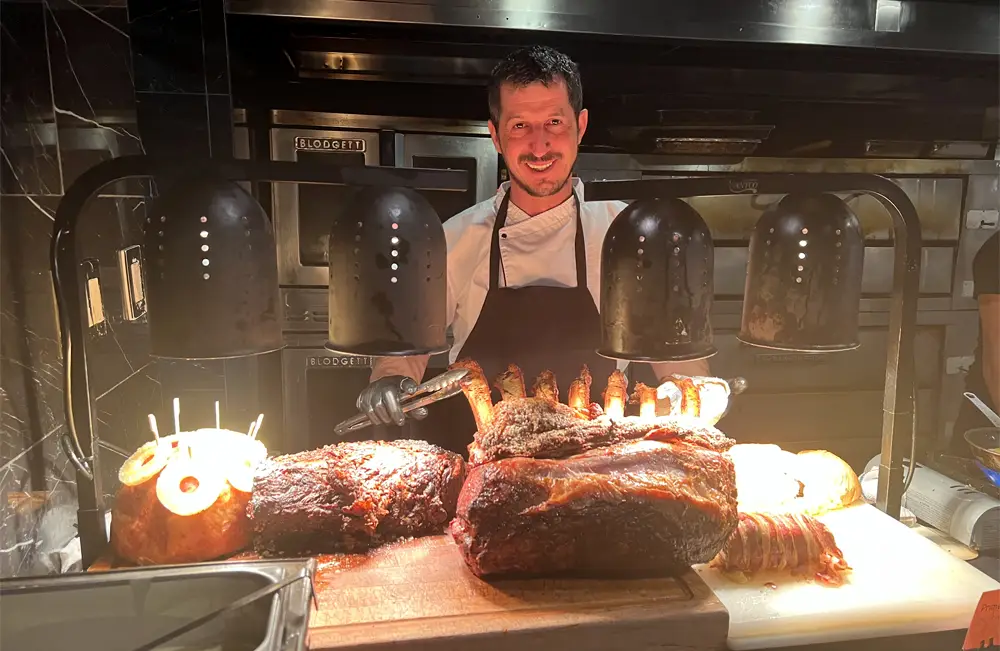 Chef in front of prime rib on cutting board