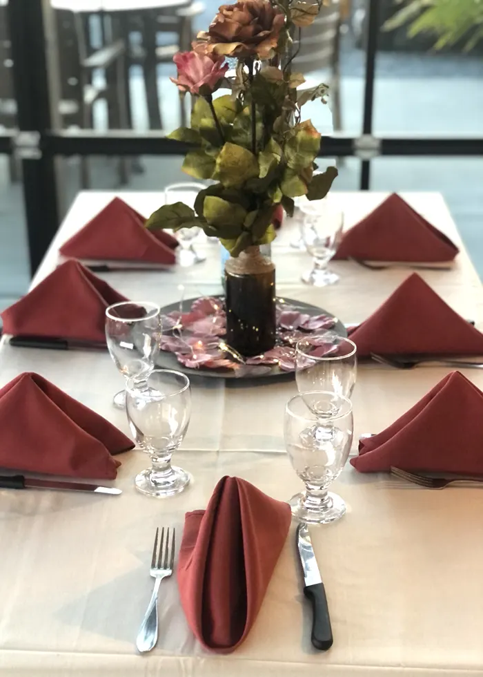 Table setting with flowers and dark red napkins
